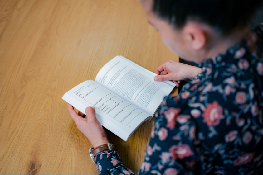 Mitarbeiterin liest Fachliteratur zur Weiterbildung